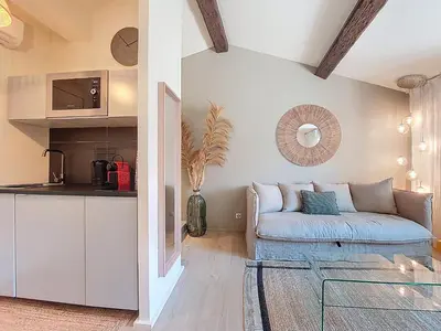 a living room with a couch and a kitchen at Nestor&Jeeves - BEIGE RIVIERA - Standing suite in Nice