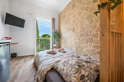a bedroom with a bed and a stone wall at Studio de Charme à Nice - Idéal télétravail - Balcon - Plage à 300m in Nice