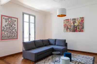 a living room with a blue couch in a white room at Grand appartement climatisé centre ville Nice in Nice