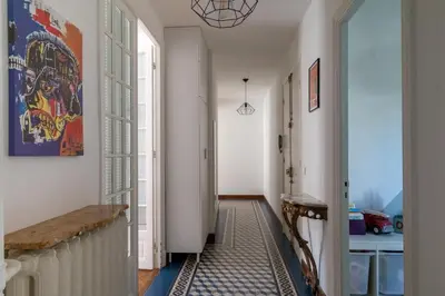 a hallway with white walls and a blue and white rug at Grand appartement climatisé centre ville Nice in Nice