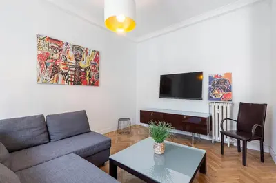 a living room with a couch and a table and a tv at Grand appartement climatisé centre ville Nice in Nice