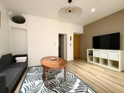 a living room with a couch and a table and a tv at Appartement cosy au coeur de la vieille ville in Nice
