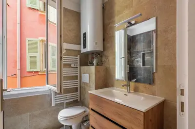 a bathroom with a sink and a toilet and a window at Appartement cosy au coeur de la vieille ville in Nice