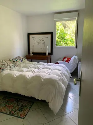 a bedroom with a large white bed and a window at L'Échappée Belle in Nice