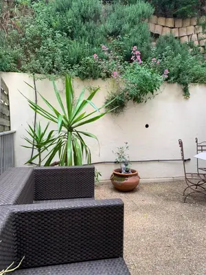 a patio with two benches and plants on a wall at L'Échappée Belle in Nice