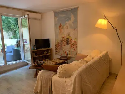 a living room with a couch and a tv at L'Échappée Belle in Nice
