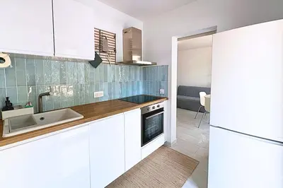 a kitchen with white cabinets and a sink at Magnifique Studio Le Renoir proche mer in Nice