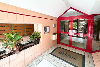 a restaurant lobby with red doors and plants on the floor at Magnifique Studio Le Renoir proche mer in Nice