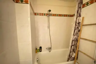 a bathroom with a tub and a shower with a shower curtain at Beautiful apartment on the heights of Nice - Parking in Nice