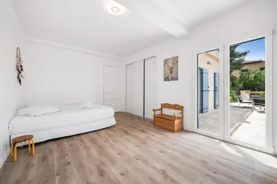 a white bedroom with a bed and a sliding glass door at La Quiétude - Spacious - Magnificent mountain view - AC - Jacuzzi in Aspremont
