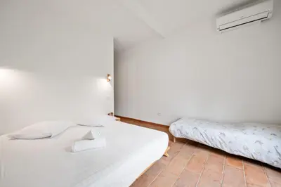 a bedroom with a white bed and a couch at La Quiétude - Spacious - Magnificent mountain view - AC - Jacuzzi in Aspremont