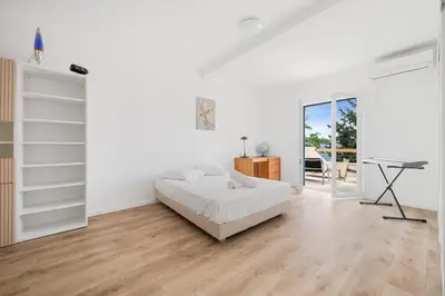a white bedroom with a bed and a desk at La Quiétude - Spacious - Magnificent mountain view - AC - Jacuzzi in Aspremont