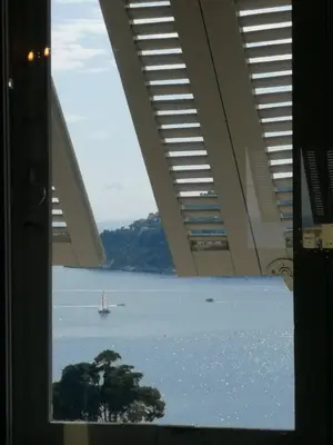 a view of a large body of water through a window at Bohemian style and luminous balcony in Nice