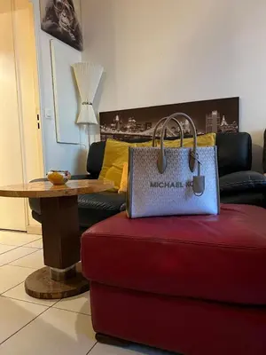 a purse sitting on top of a red couch in a living room at Studio magnan grand balcon in Nice