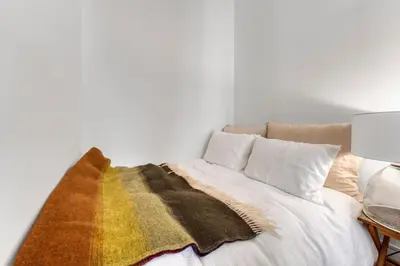 a bedroom with a bed with a blanket on it at Nice design, calme & gare à 5 min à pied in Nice
