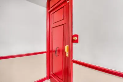 a red door on the side of a white wall at Nice design, calme & gare à 5 min à pied in Nice