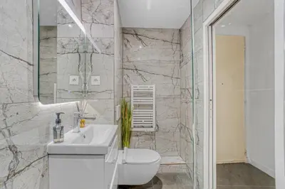 a bathroom with a sink and a toilet and a mirror at Nice design, calme & gare à 5 min à pied in Nice