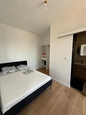 a bedroom with a white bed and a wooden floor at Studio Nice proximité du port in Nice