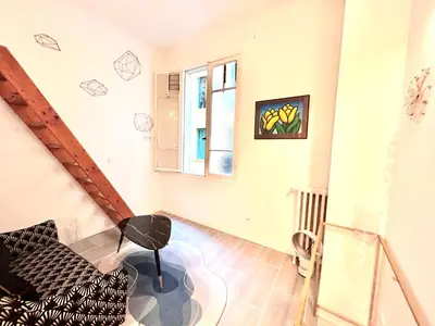 a living room with a couch and a window at Studio close to Main Street and Train Station in Nice