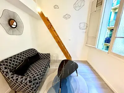 a living room with a chair and a window at Studio close to Main Street and Train Station in Nice
