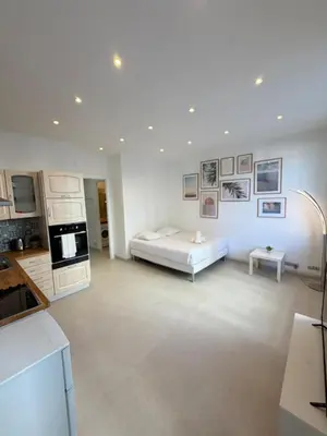 two beds in a white room with pictures on the wall at Plein centre clim, proche gare et tramway in Nice
