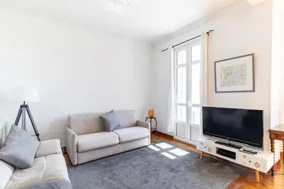 a living room with a couch and a flat screen tv at HappyFew suite Palazzo in Nice