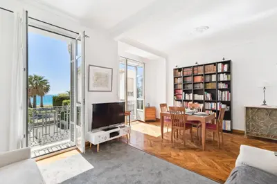 a living room with a television and a table with a dining room at HappyFew suite Palazzo in Nice