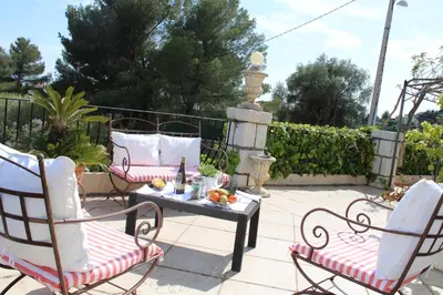 a patio with two chairs and a table and a fountain at Magnifique Villa sur les collines de Nice, 6 Pièces, clim, barbecue, sauna et hammam in Nice