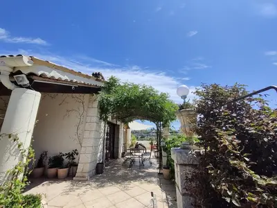a building with an archway and a table and chairs at Magnifique Villa sur les collines de Nice, 6 Pièces, clim, barbecue, sauna et hammam in Nice