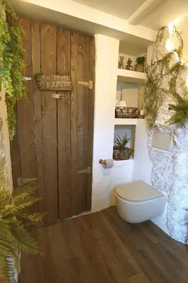 a bathroom with a toilet and a wooden door at Suite des aventuriers - Expérience Unique & Atypique à Nice proche du centre in Nice