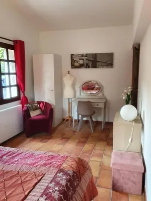 a bedroom with a bed and a desk and a chair at A la campagne aux portes de Nice in Falicon