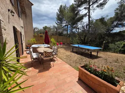 a patio with a ping pong table and chairs at A la campagne aux portes de Nice in Falicon