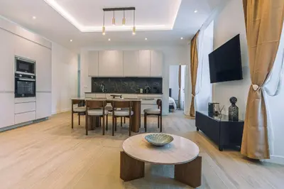 a kitchen and living room with a table and chairs at Magnifique appartement - Jacuzzi - Port de Nice in Nice