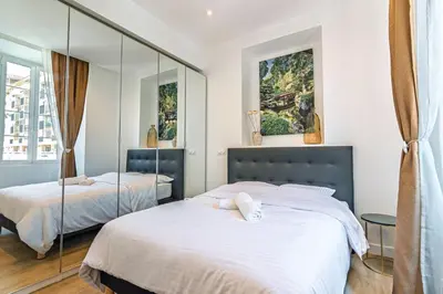 two beds in a bedroom with mirrors at Magnifique appartement - Jacuzzi - Port de Nice in Nice