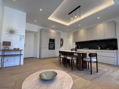 a kitchen with a table and chairs in a room at Magnifique appartement - Jacuzzi - Port de Nice in Nice