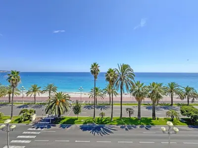 a view of a parking lot with palm trees and the ocean at Nice Seaview Loft Promenade in Nice