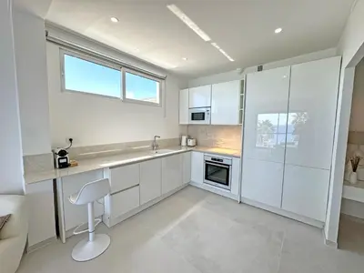 a kitchen with white cabinets and a window at Nice Seaview Loft Promenade in Nice
