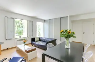 a living room with a blue couch and a table at Jardin tropical, parking, climatisation in Nice
