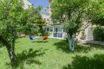 two chairs sitting in the yard of a house at Jardin tropical, parking, climatisation in Nice