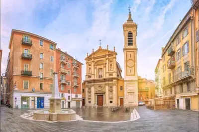 a building with a clock tower in a city at Jardin tropical, parking, climatisation in Nice
