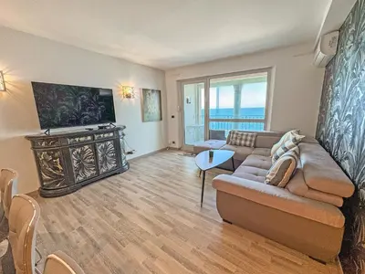 a living room with a couch and a television at Panoramic Pebbles Azur in Nice