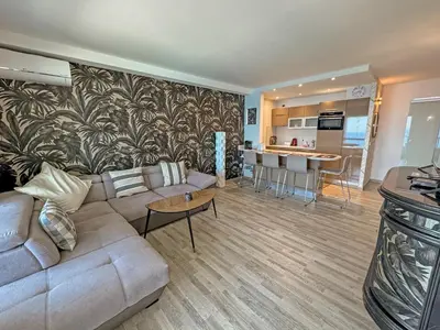 a living room with a couch and a kitchen at Panoramic Pebbles Azur in Nice