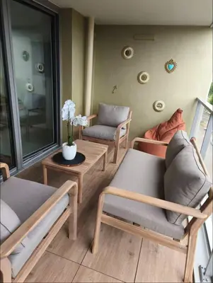 a living room with couches and a table with flowers at Piscine Rooftop Résidence Neuve in Saint-Laurent-du-Var