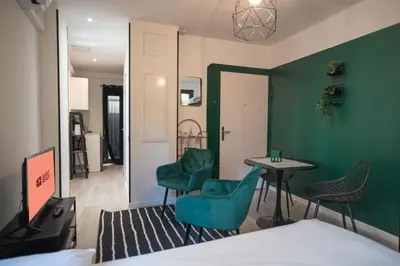 a room with green walls and a table and chairs at Gambetta stay near attractions in Nice