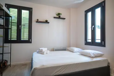 a bedroom with a bed with two pillows and two windows at Gambetta stay near attractions in Nice