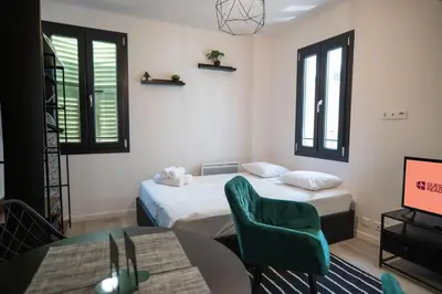 a room with two beds and a table and a tv at Gambetta stay near attractions in Nice