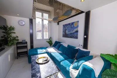 a living room with a blue couch and a table at Duplex suite 50m de la plage Carré d'Or Nice in Nice