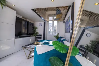 a room with a bed and a table with a mirror at Duplex suite 50m de la plage Carré d'Or Nice in Nice