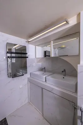 a white bathroom with two sinks and a mirror at Duplex suite 50m de la plage Carré d'Or Nice in Nice