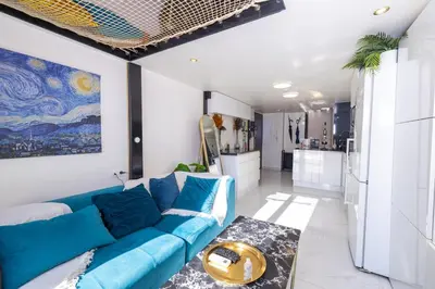 a living room with a blue couch and a kitchen at Duplex suite 50m de la plage Carré d'Or Nice in Nice